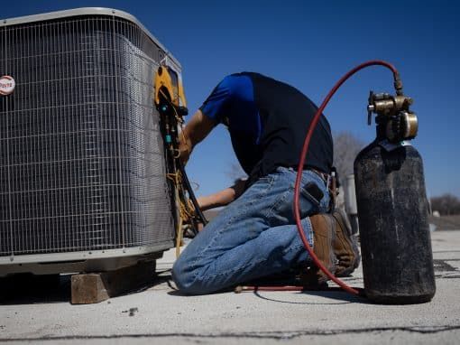 Technician servicing an outdoor AC unit